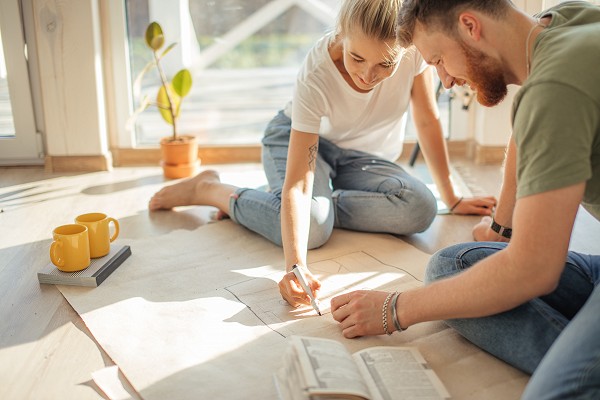 Portrait of happy Caucasian couple planning new house design looking at paper